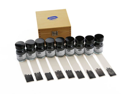 Set of ink bottles with application strips and a wooden box on a white background